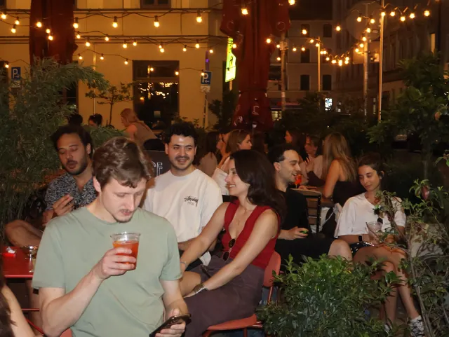 Guests on JUNE’s terrace under string lights